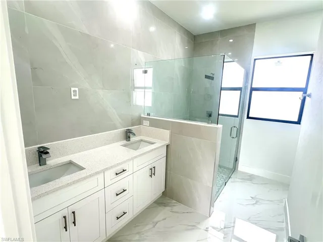 Bathroom featuring vanity and an enclosed shower
