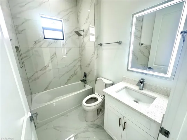 Full bathroom featuring vanity, toilet, and tiled shower / bath