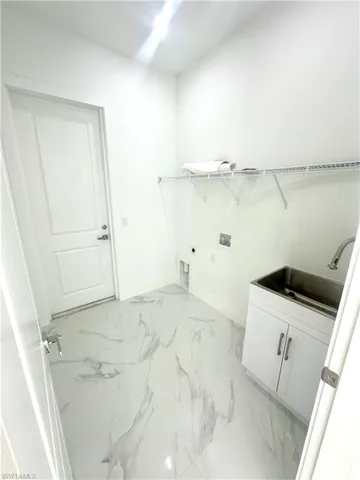 Clothes washing area with cabinets, sink, washer hookup, and electric dryer hookup
