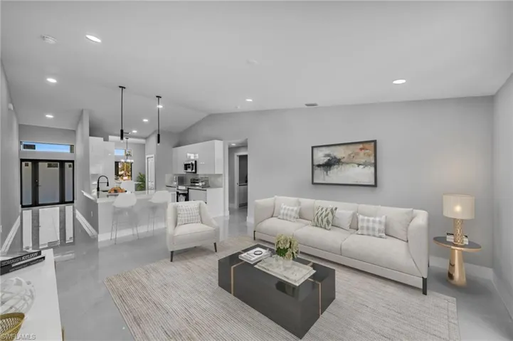 Living room featuring sink and vaulted ceiling