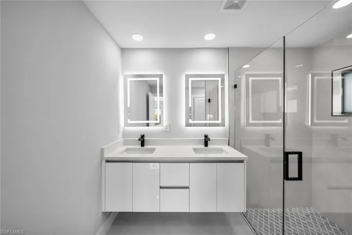 Bathroom featuring an enclosed shower and vanity