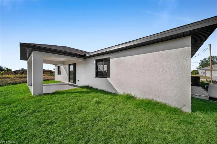 Rear view of property featuring a yard and a patio area
