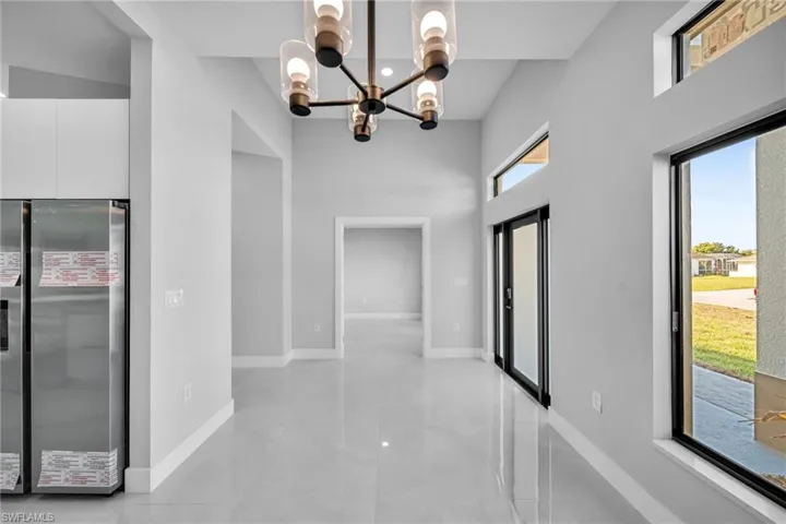 Corridor with a notable chandelier and a high ceiling
