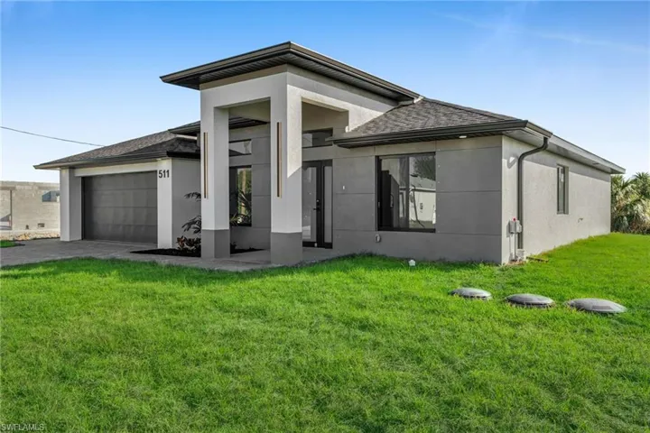 View of front of property featuring a garage and a front yard