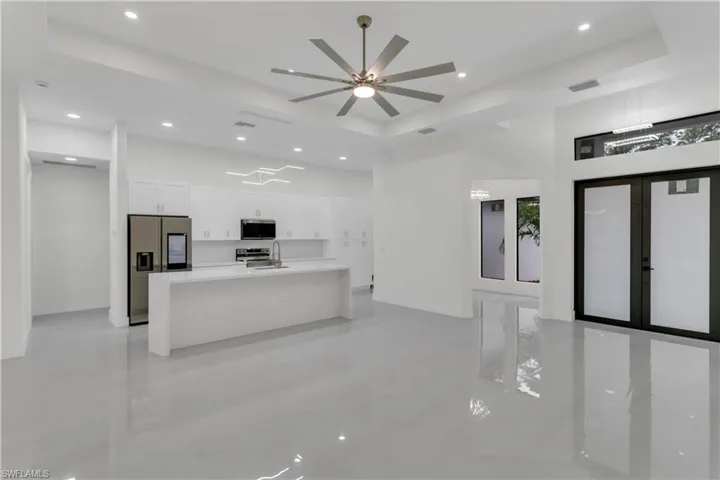 Kitchen with stainless steel appliances, a tray ceiling, white cabinetry, and visible vents