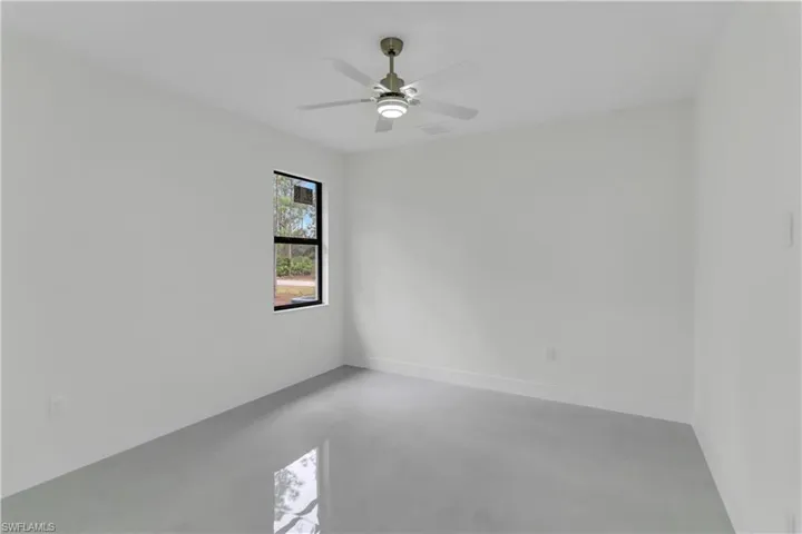 Spare room with concrete flooring, visible vents, baseboards, and a ceiling fan