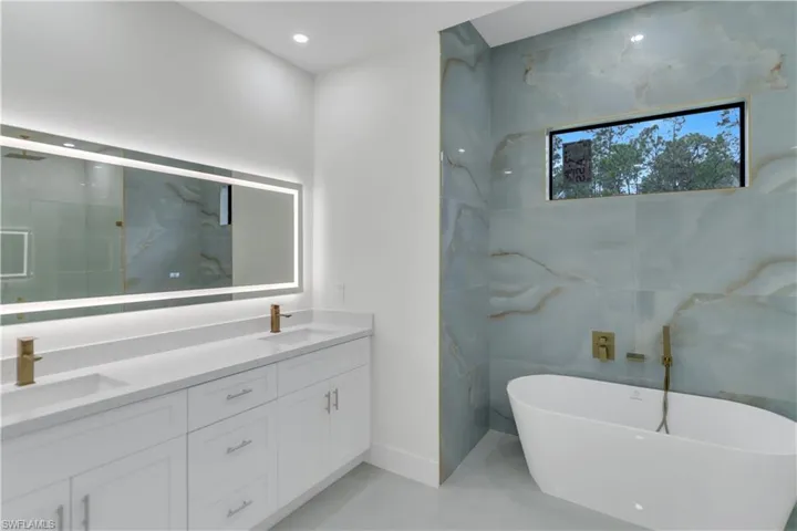 Full bath with a soaking tub, a sink, and double vanity