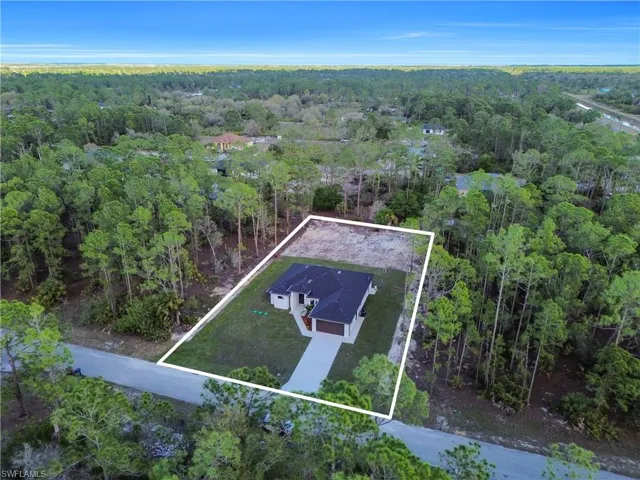 Birds eye view of property featuring a forest view