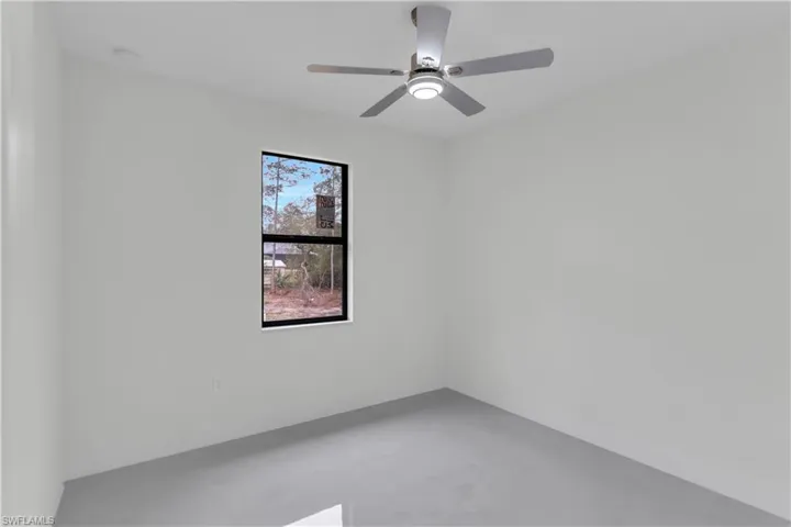 Empty room with concrete floors and ceiling fan