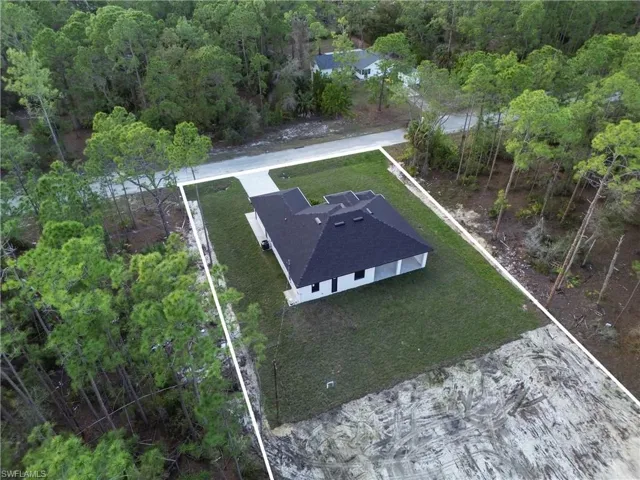 Birds eye view of property featuring a forest view