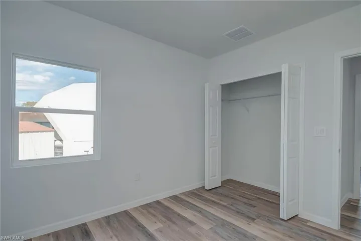 Unfurnished bedroom with light wood-type flooring and a closet