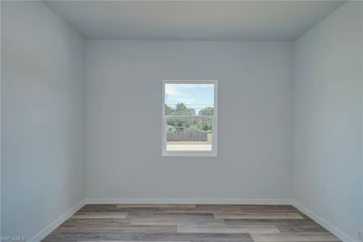 Empty room with light wood-type flooring and baseboards