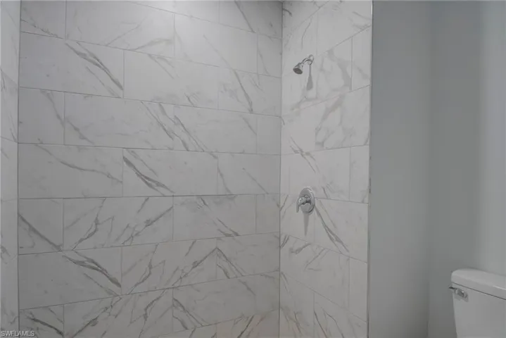 Bathroom with toilet and a tile shower