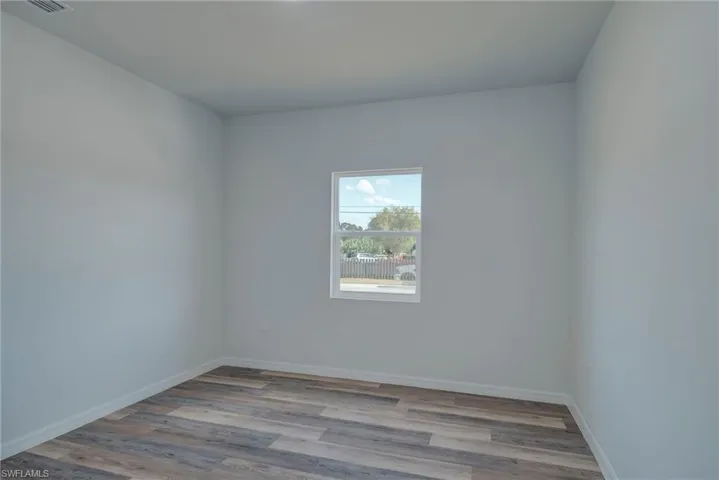 Unfurnished room with light wood finished floors and baseboards