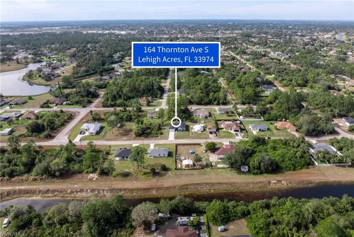 Aerial overview of property's location featuring a nearby body of water and nearby suburban area