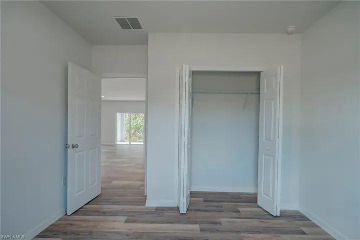 Unfurnished bedroom featuring wood finished floors and a closet