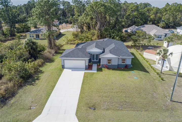 Aerial view of property and surrounding area with a tree filled landscape