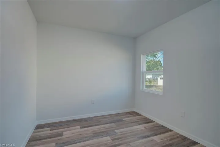 Spare room featuring light wood-style floors and baseboards