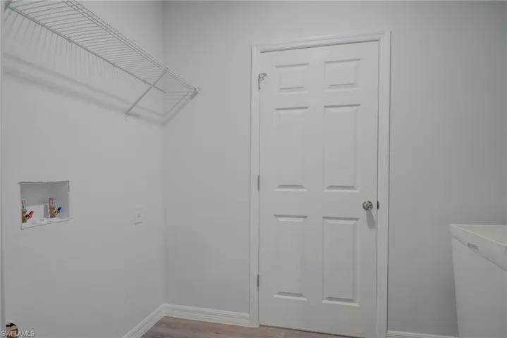 Laundry room featuring wood finished floors and washer hookup