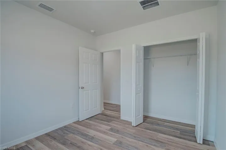 Unfurnished bedroom featuring light wood-style floors and a closet