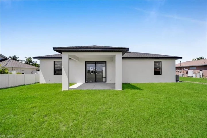 Back of property featuring a patio, stucco siding, and roof with shingles
