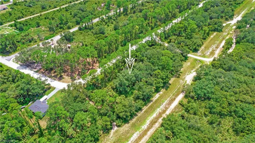 Aerial view of property and surrounding area featuring a heavily wooded area