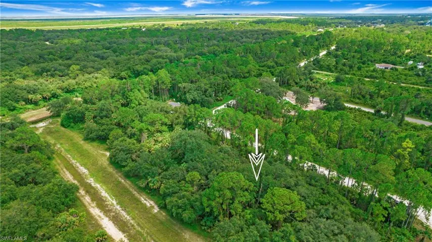 Aerial view of property's location featuring a heavily wooded area