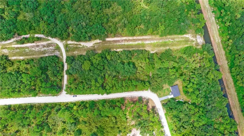 Aerial overview of property's location with a heavily wooded area