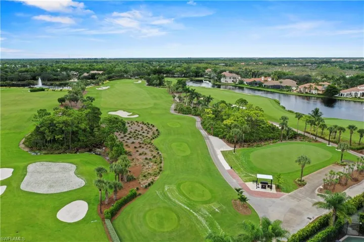 Aerial perspective of suburban area with a large body of water and a golf course