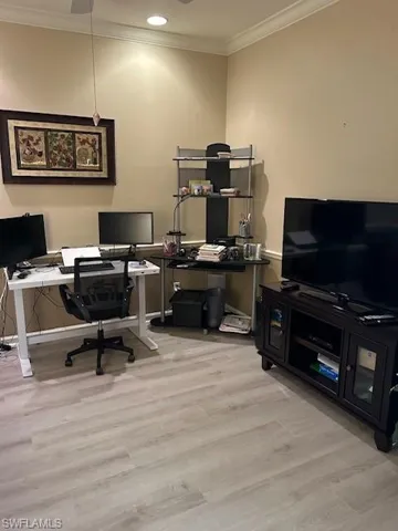 Office space with crown molding and light wood-type flooring