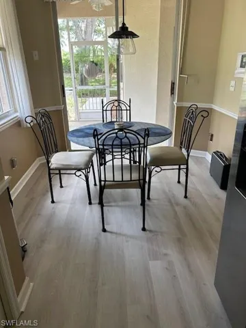 Dining area with light wood-style flooring and baseboards