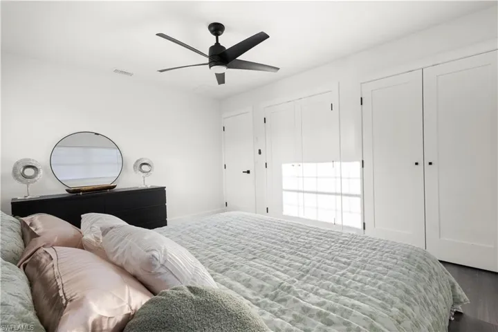 Bedroom featuring hardwood / wood-style flooring, two closets, and ceiling fan