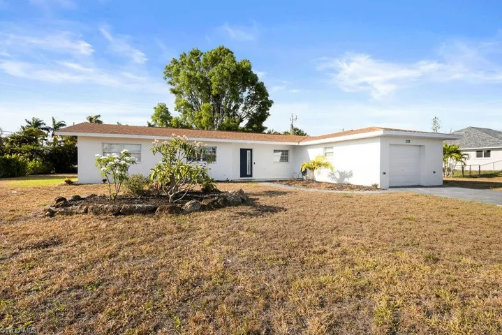 Ranch-style home with a garage and a front yard