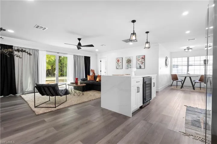 Kitchen featuring decorative light fixtures, white cabinets, dark hardwood / wood-style floors, and wine cooler