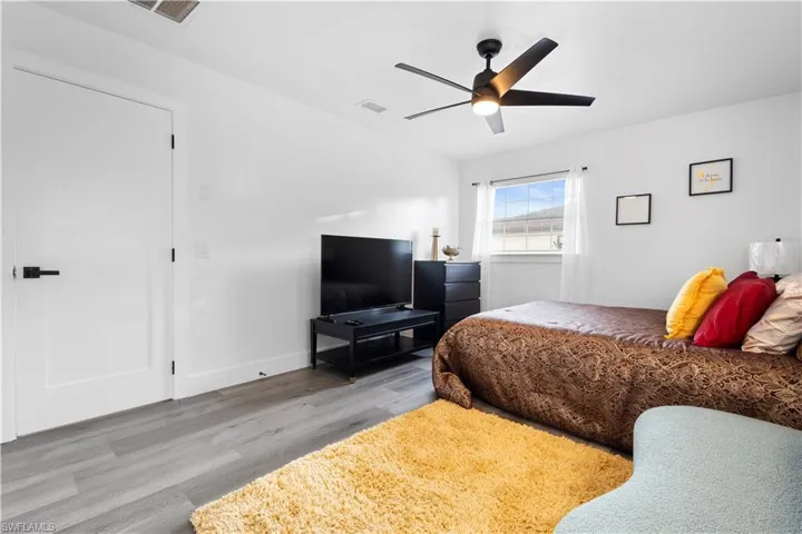Bedroom with ceiling fan and hardwood / wood-style floors
