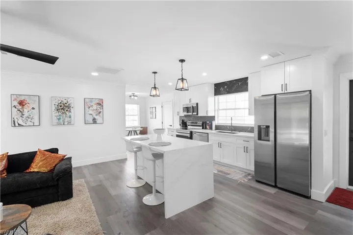 Kitchen featuring hardwood / wood-style floors, stainless steel appliances, and white cabinets