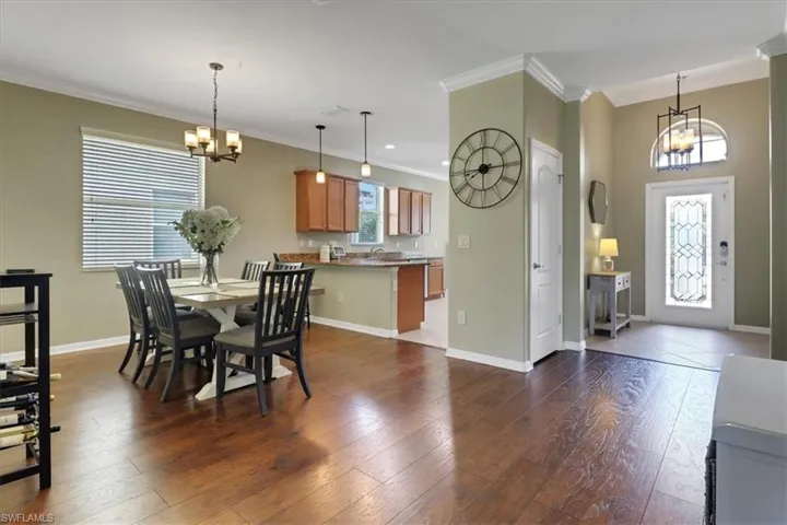 Dining room with an inviting chandelier, a healthy amount of sunlight, and ornamental molding