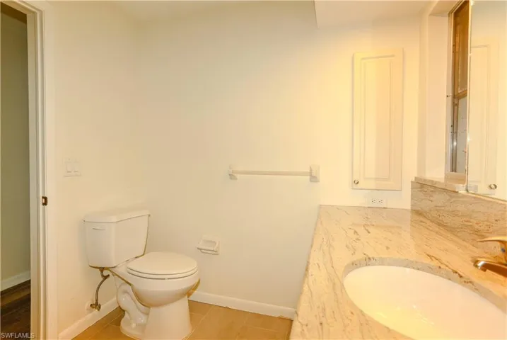 Bathroom featuring a built-in vanity with a polished stone countertop and an undermount sink