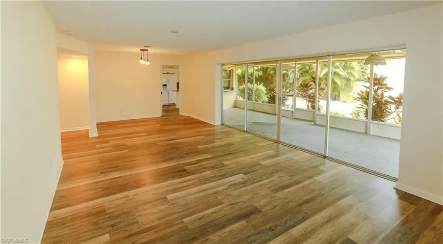 Expansive living area featuring wood-finish flooring, neutral wall tones, and recessed lighting