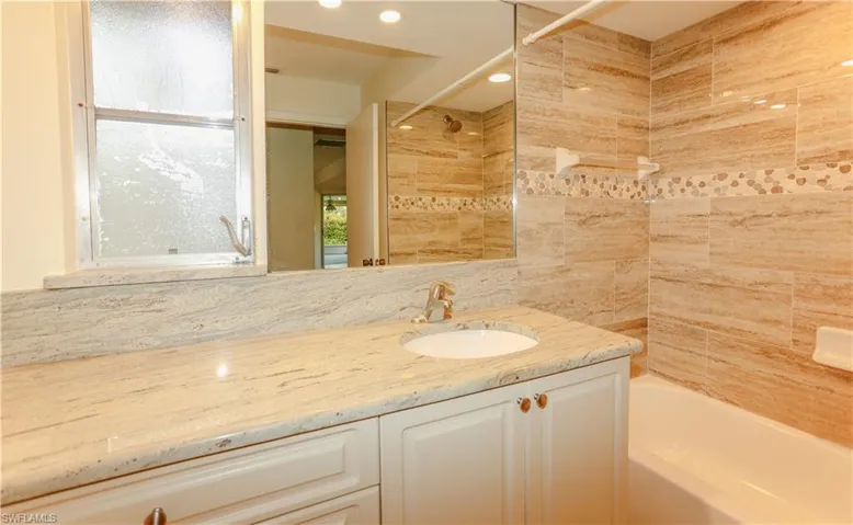 Bathroom featuring a white vanity with a light-toned countertop, an undermount sink, and a chrome faucet