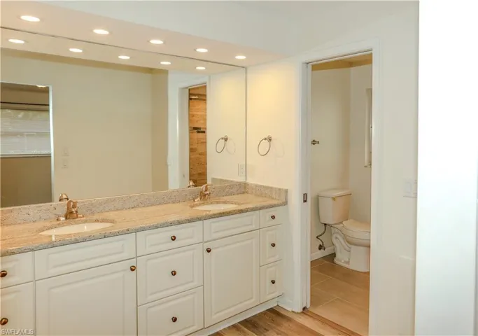 Dual vanity with granite-finish countertop, undermount sinks, and white cabinetry