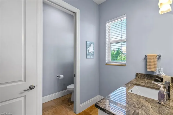 Bathroom vanity featuring a granite countertop with an undermount sink and private water closet