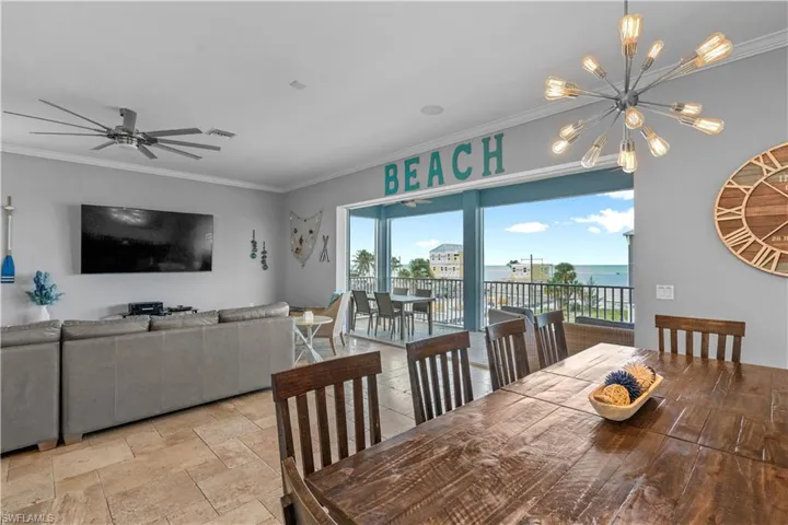 Open-concept living and dining area featuring tile flooring, a large wood dining table, and direct access to an exterior balcony