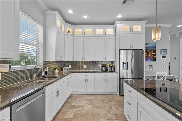 Kitchen featuring white shaker-style cabinetry, granite countertops, and a full suite of stainless steel appliances