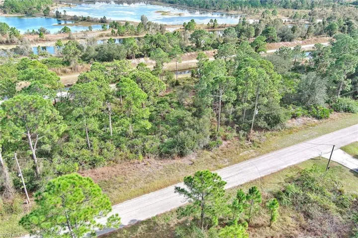View of property location with a large body of water and a heavily wooded area