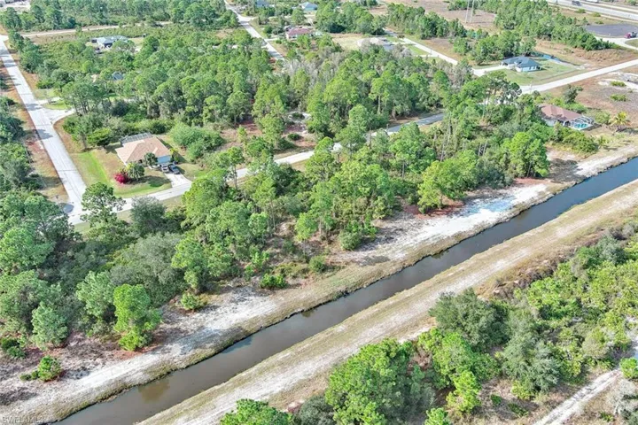 View of property location with a large body of water and a tree filled landscape