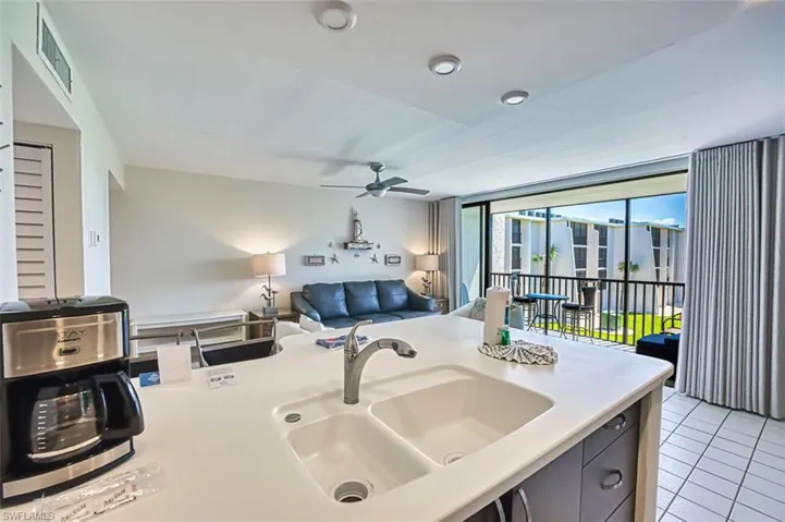 Kitchen with light tile patterned floors, open floor plan, and ceiling fan