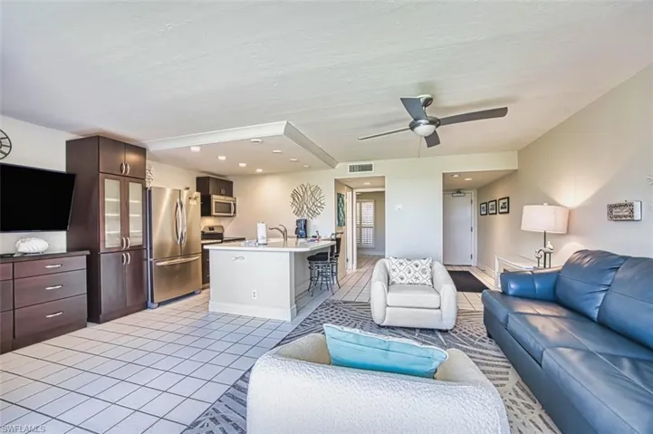 Living room featuring light tile patterned flooring, a ceiling fan, and recessed lighting