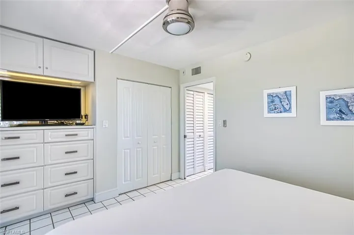 Bedroom with light tile patterned floors and a closet
