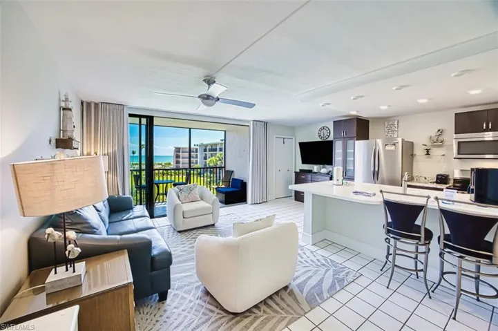 Living room with light tile patterned flooring, ceiling fan, and floor to ceiling windows